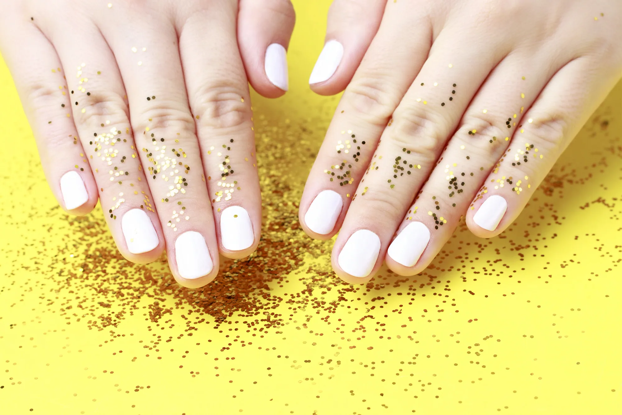 White manicure with gold glitter styling